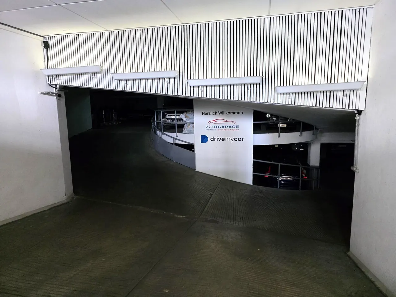 Eingang zur Tiefgarage mit Zürigarage- und drivemycar-Logo